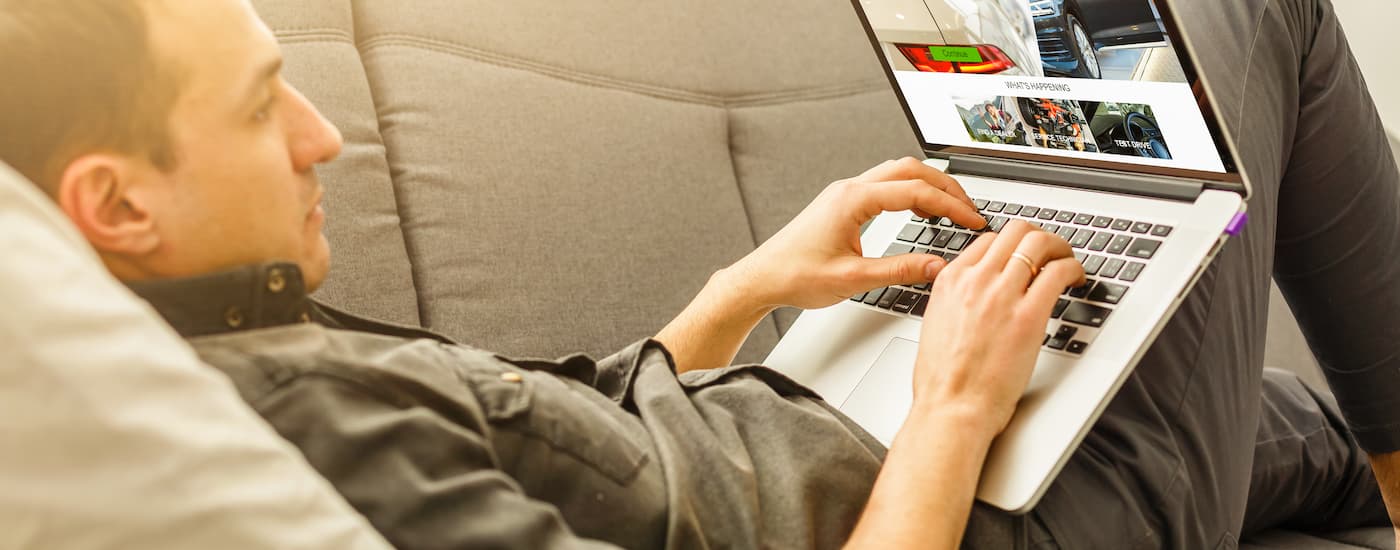 Man using a laptop to finance his car at home