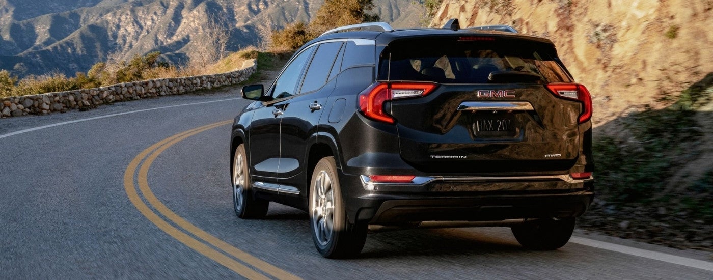 A black 2023 GMC Terrain Denali is shown from the rear at an angle.