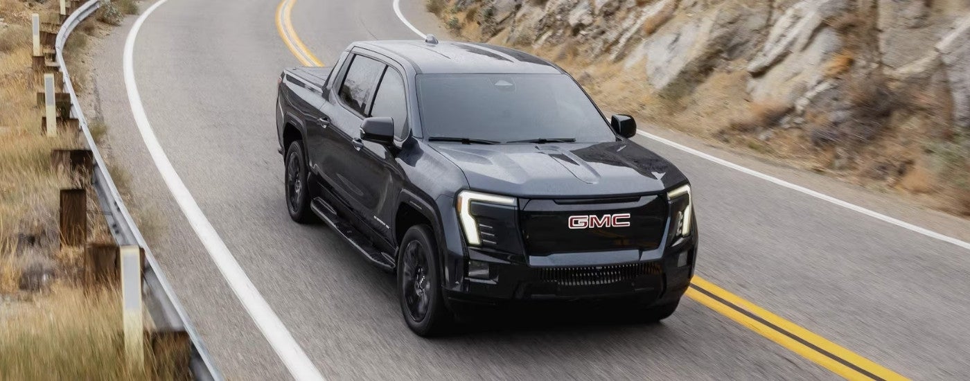 Black 2026 GMC Sierra EV Elevation driving on a highway