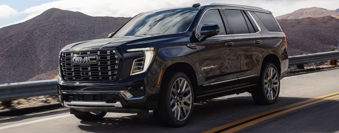 Black 2026 GMC Yukon Denali driving on a highway