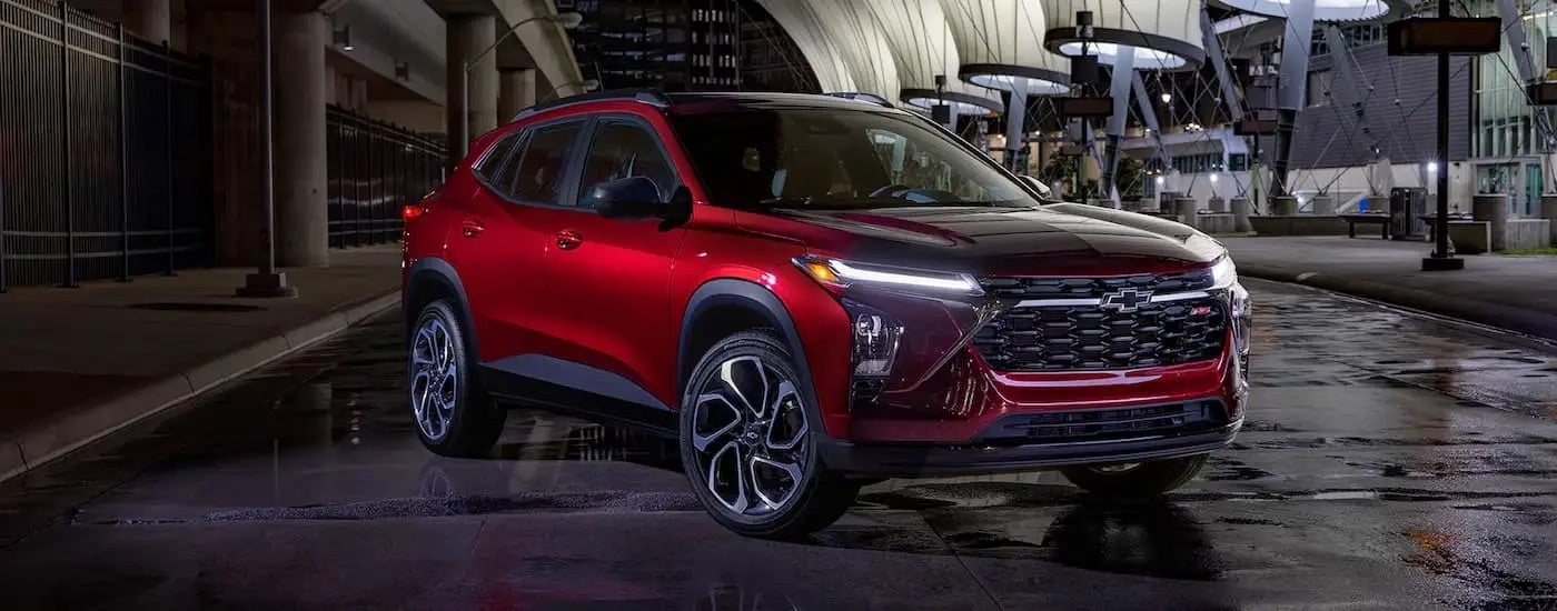 A red 2025 Chevy Trax 2RS parked under lights at night.