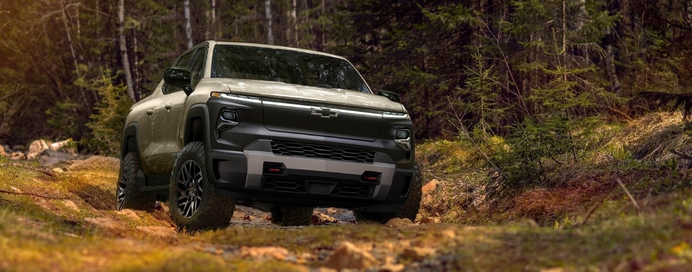 A silver 2024 Chevy Silverado EV Trail Boss is shown in the woods after leaving a Chevy dealer in Collierville, TN.