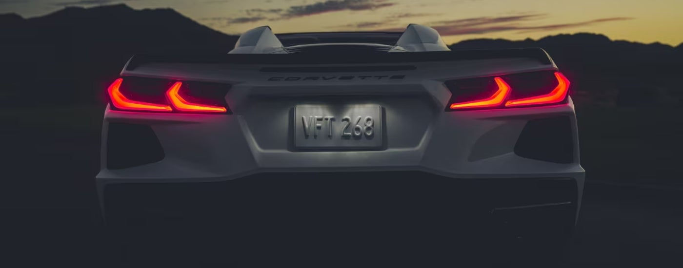 A white 2021 Chevy Corvette is shown at night with the taillights illuminated.