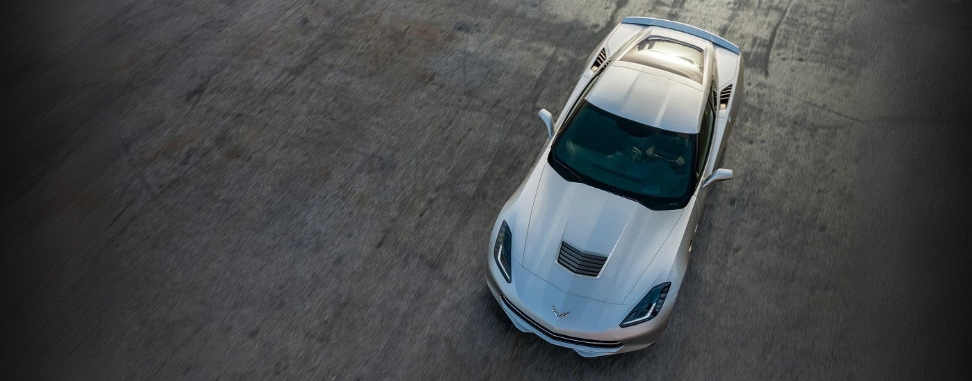 A silver 2019 Chevy Corvette Stingray is shown from a high angle on pavement.