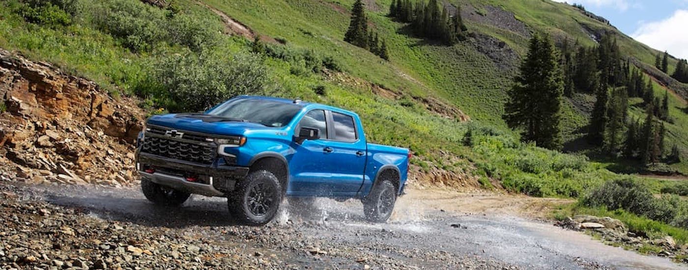 A blue 2024 Chevy Silverado 1500 ZR2 is shown from the front at an angle.
