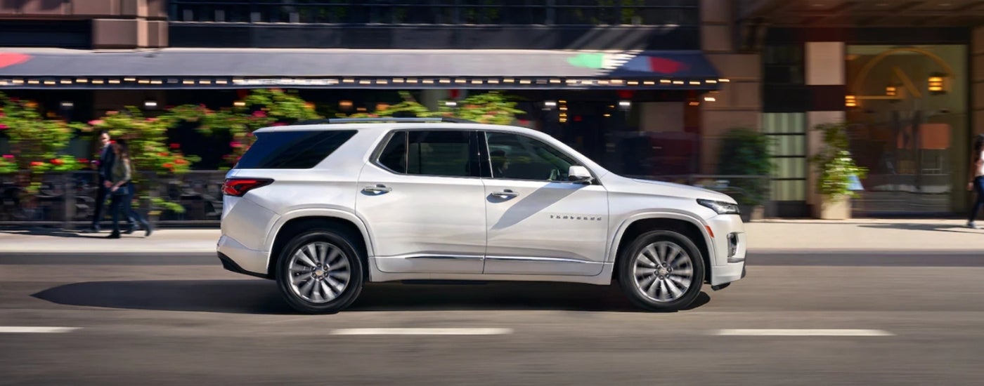 A white 2023 Chevy Traverse is shown on a city street after leaving a Chevy Traverse dealer.