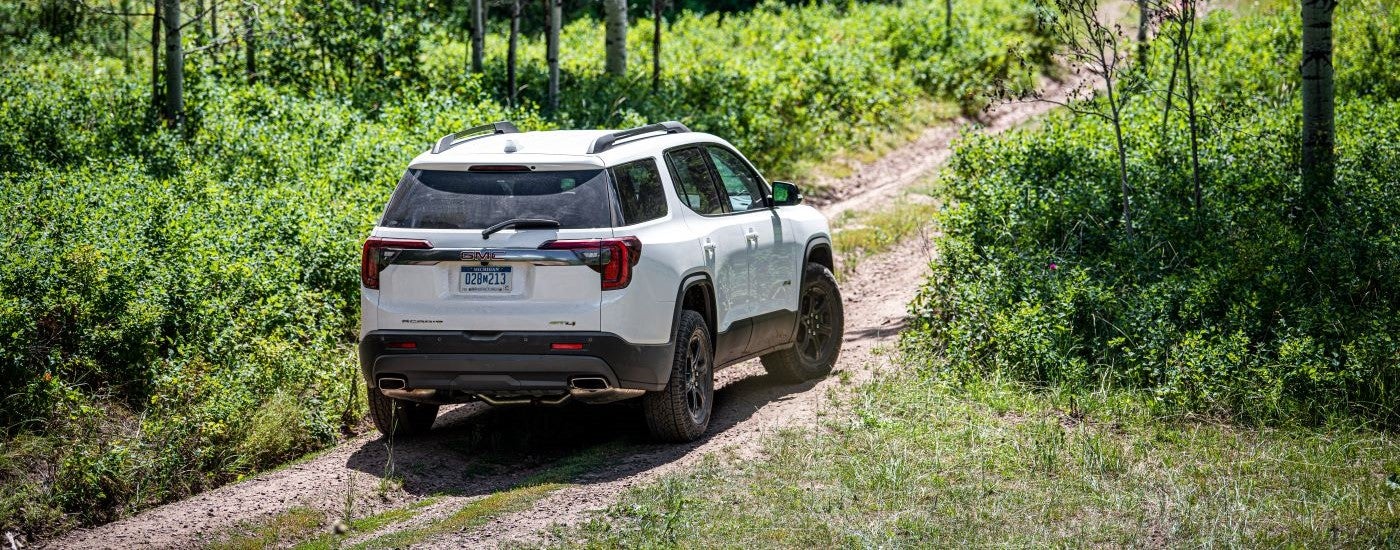 White 2020 GMC Acadia AT4 driving on a trail