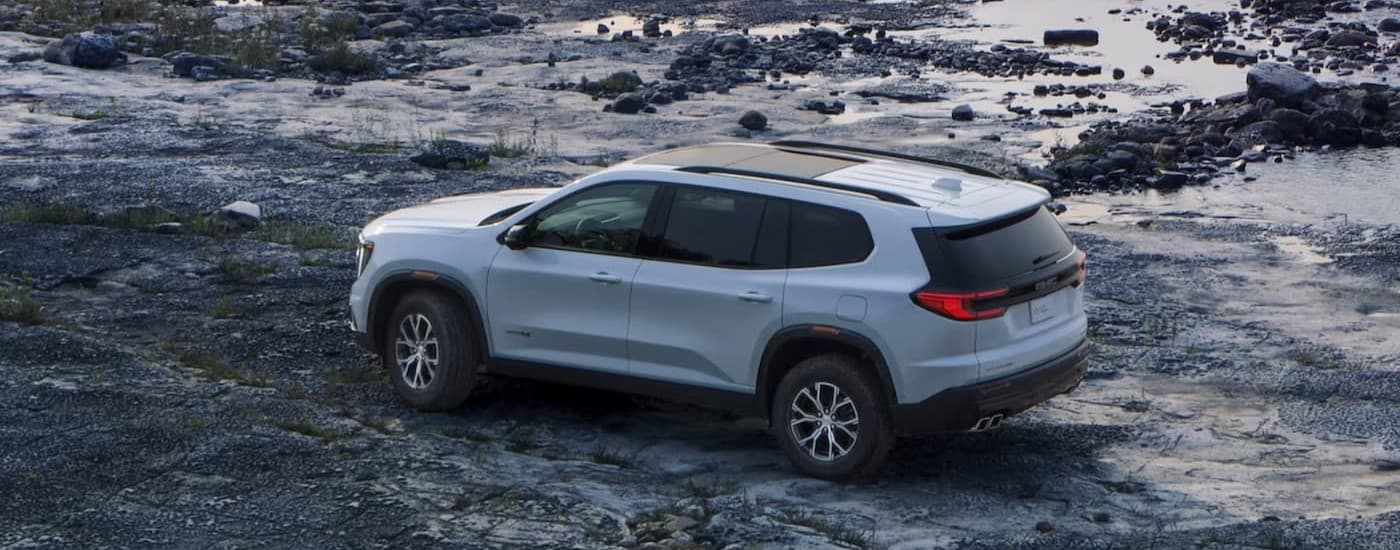 A white 2025 GMC Acadia parked offroad.