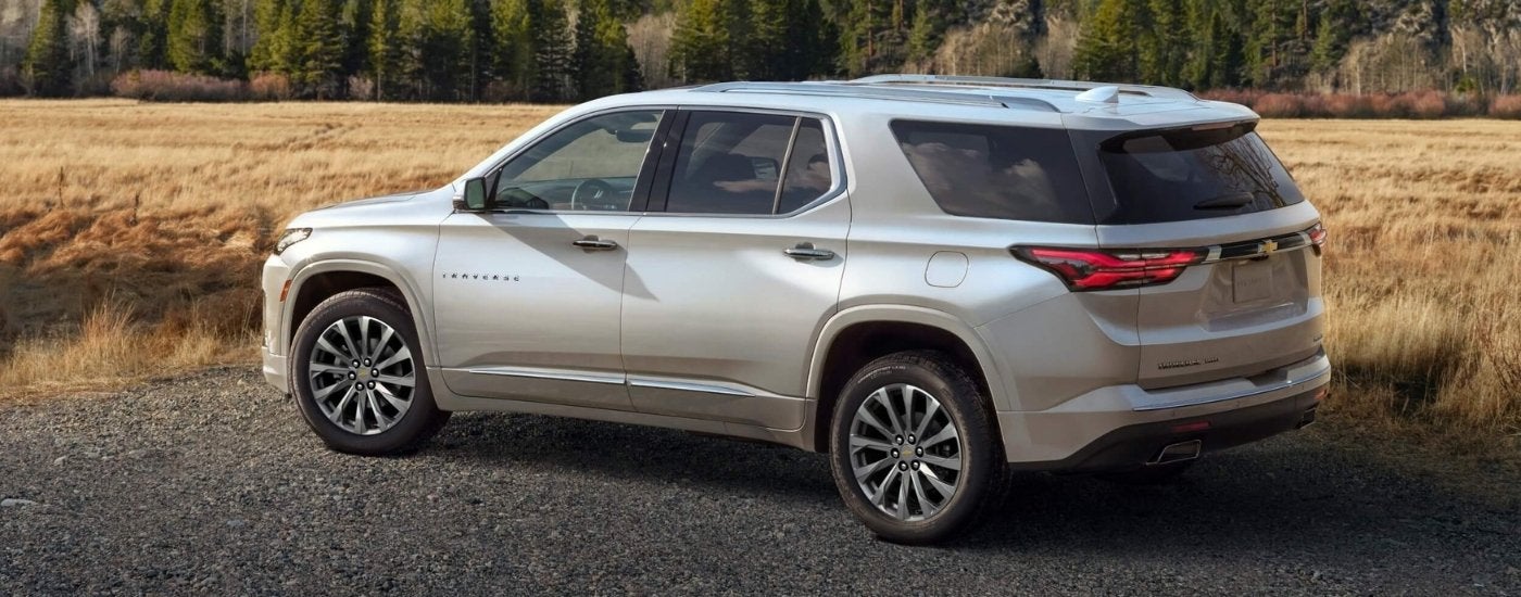 A silver 2022 Chevy Traverse Premier is shown parked on gravel.