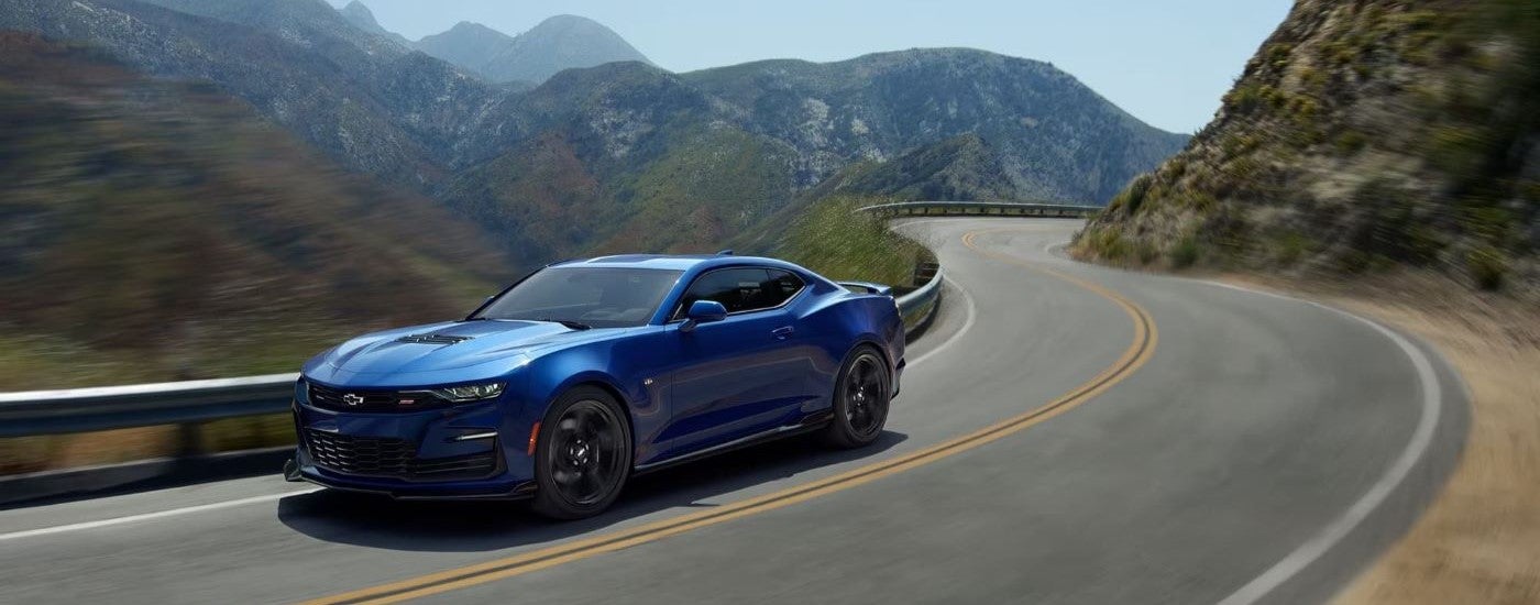 A blue 2021 Chevy Camaro 2SS driving on a winding mountain road.