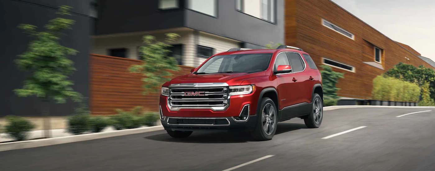 A red 2021 GMC Acadia is shown driving to a Tupelo GM dealer.