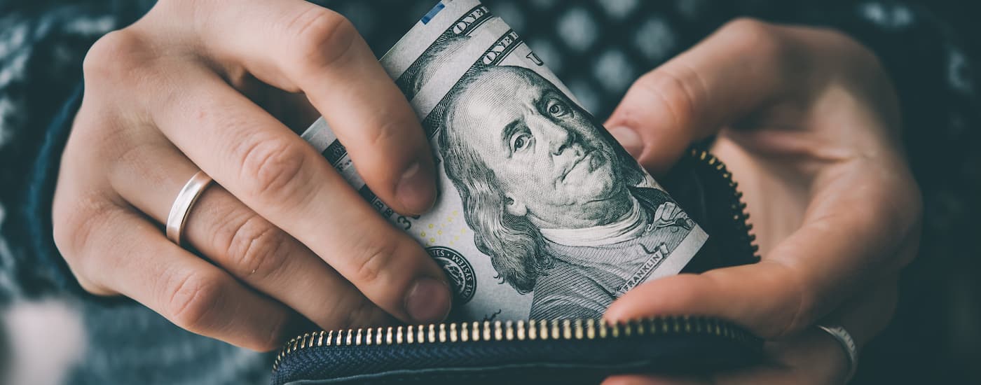 A person is shown holding cash.