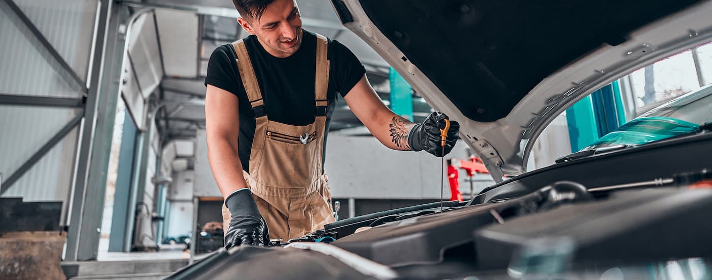 A mechanic is shown checking a dipstick during an oil change.