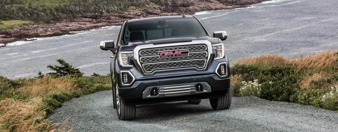 Grey 2020 GMC Sierra 1500 Denali driving on a rocky road.
