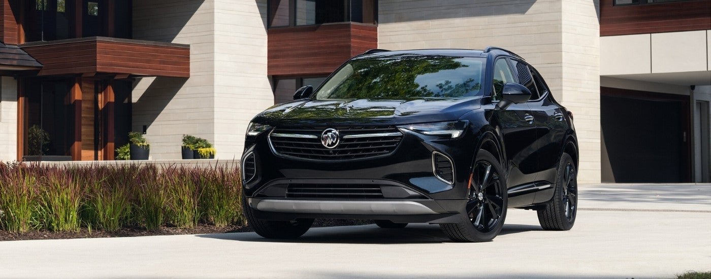 A black 2021 Buick Envision is shown from the front parked in front of a modern house.