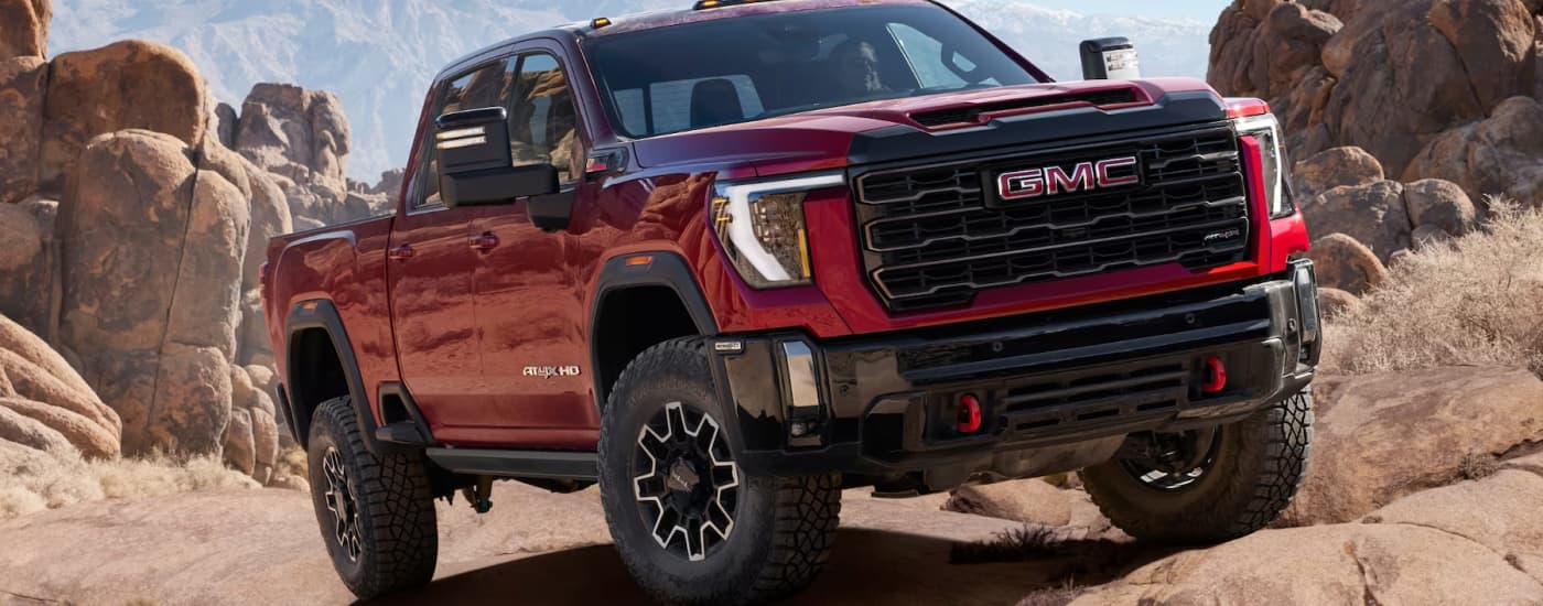 A red 2025 GMC Sierra 2500 HD AT4X parked off-road
